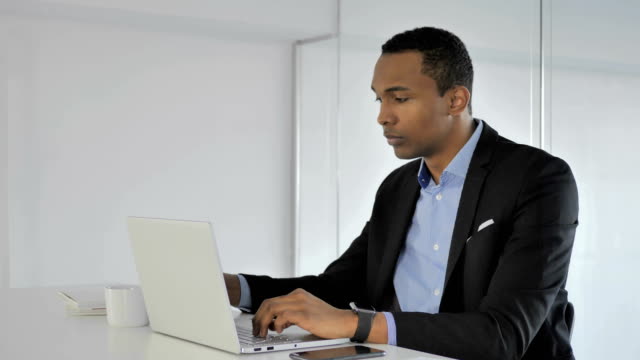 Informal-afroamericana-empresario-beber-café-mientras-trabajaba-en-la-computadora-portátil