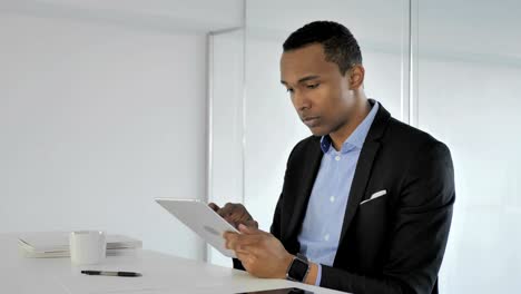Lässige-afroamerikanischer-Geschäftsmann-Surfen-Internet-auf-dem-Tablet-PC