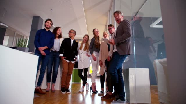 multicultural-group-of-employees-standing-together-during-office-studio-meeting.