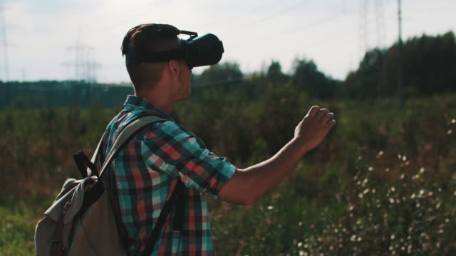 Junge-mit-Rucksack-auf-Straße-zu-virtual-Reality-Brille-betrachten.-Gerät.-Sommer