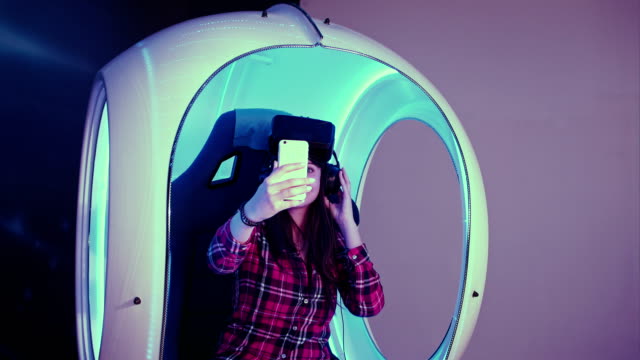 Smiling-girl-wearing-virtual-reality-glasses-taking-selfies-on-her-phone