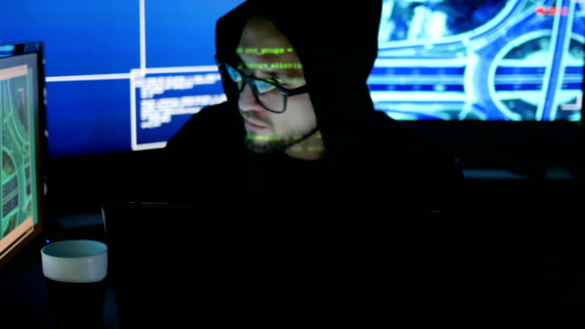 cyber-security-center-filled-with-display-screens,-Male-hacker-working-on-computer,-IT-professional-programmer-in-glasses-is-working-on-computer