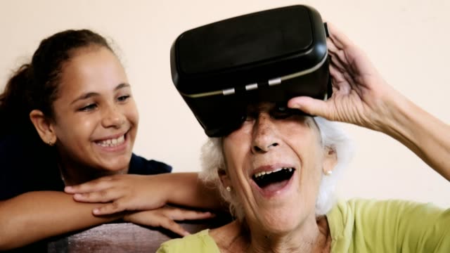Juego-de-VR-con-feliz-abuela-y-niña-jugando-sonriendo-riendo