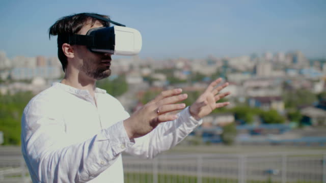 Mann-gekleidet-virtual-Reality-Brille-auf-dem-Hintergrund-der-Stadt.