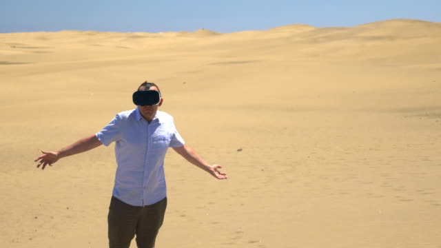 Video-of-man-exploring-virtual-reality-on-the-desert-in-4k