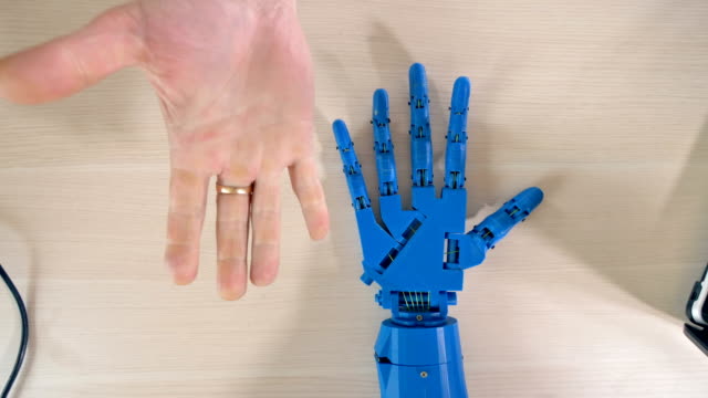 Mano-robótica-repitiendo-movimientos-de-mano-derecha-del-hombre.