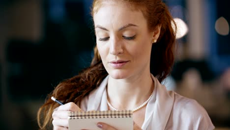 Redhead-woman-writing-on-notepad-portrait.Corporate-business-team-work-office-meeting.Caucasian-businessman-and-businesswoman-people-group-talking-together.Collaboration,growing,success.4k-video