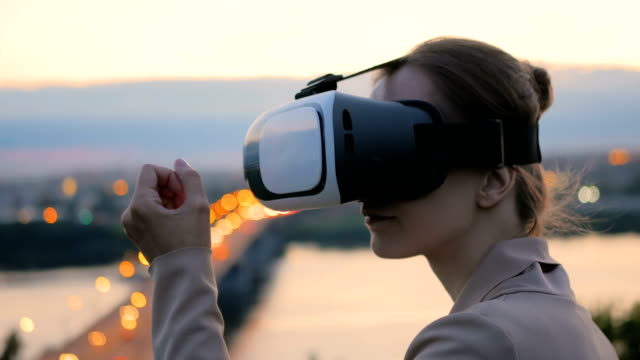 Frau-nutzt-virtual-Reality-Brille-in-der-Stadt-nach-Sonnenuntergang