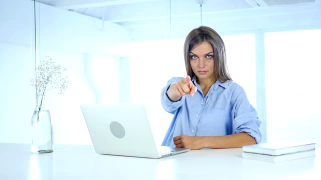 Woman-Pointing-at-Camera-in-Office-at-Work
