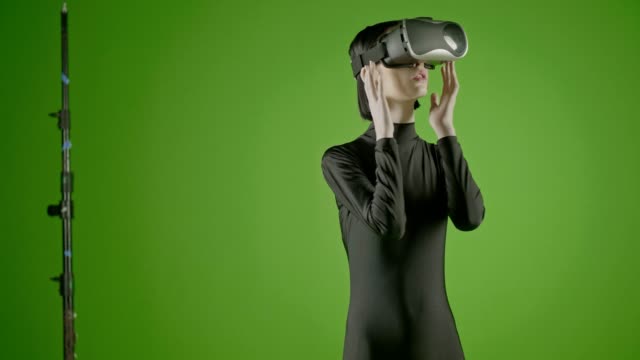 Modelo-de-moda-joven-chica-atractiva-usando-un-auricular-VR-en-pantalla-verde