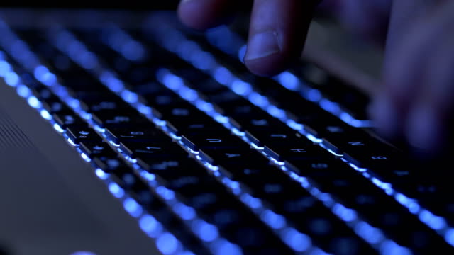 Typing-on-the-illuminated-laptop-at-night
