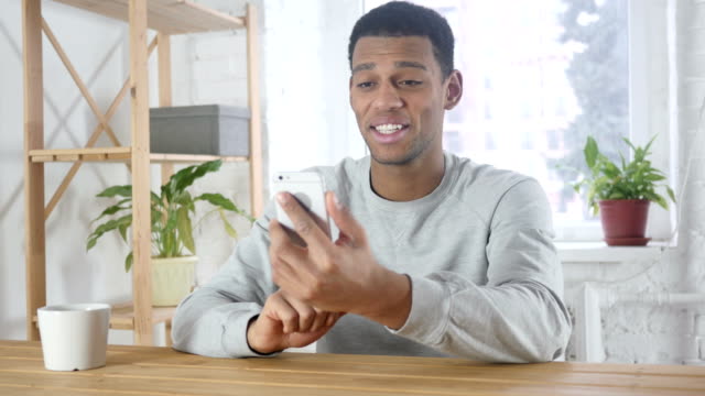 Smartphone-Video-Chat-von-jungen-afroamerikanischen-Mann-im-Büro