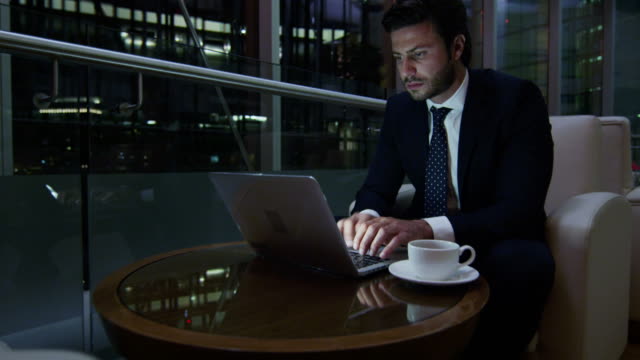 Arabic-businessman-hotel-atrium-night-using-laptop-computer