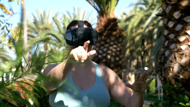 Video-de-mujer-explorando-la-realidad-virtual-en-el-resort-tropical-en-4k