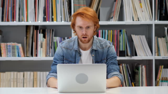 Hombre-sorprendido,-aturdido-con-pelos-rojos-trabajando-en-ordenador-portátil