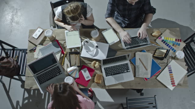 Diseñadores-que-trabajan-juntos-en-la-mesa-de-oficina