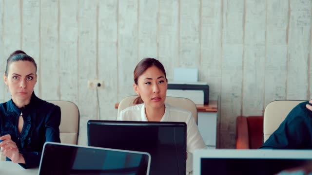 Asiatin-hinter-Laptops-im-Büro-mit-Kollegen,-kommuniziert-sie-team-diskutieren-Geschäftsideen