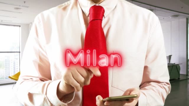 Milan.-Businessman-chooses-а-city-on-virtual-interface-in-light-office.-Concept:-business-trip,hologram,-technology,-augmented-reality,-future,-travel