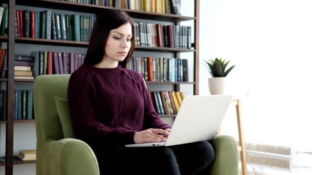 Mujer-joven-escribiendo-en-la-Laptop-en-la-oficina