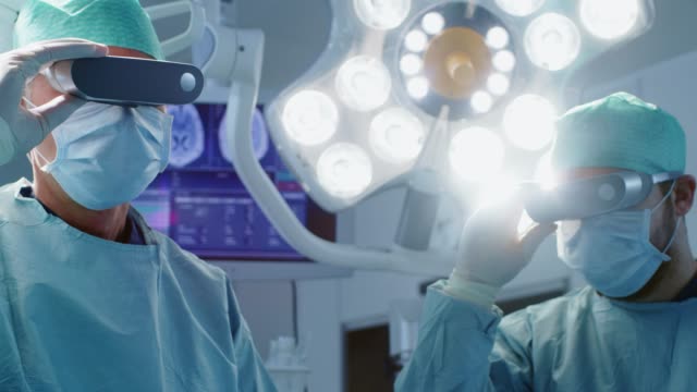 Surgeons-Put-on-Augmented-Reality-Glasses-to-Perform-State-of-the-Art-Surgery-in-High-Tech-Hospital.-Doctors-and-Assistants-Working-in-Operating-Room.