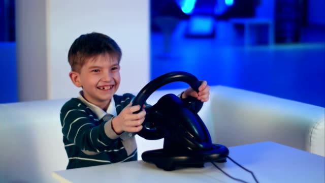 Happy-excited-little-boy-playing-videogame-with-racing-wheel