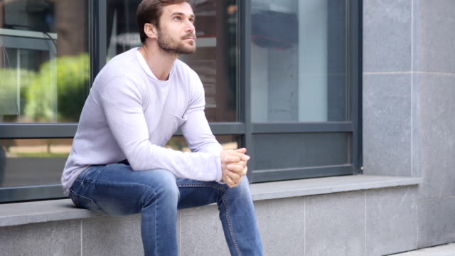 Serious-Handsome-Man-Sitting-Outside-Office-and-Looking-Around