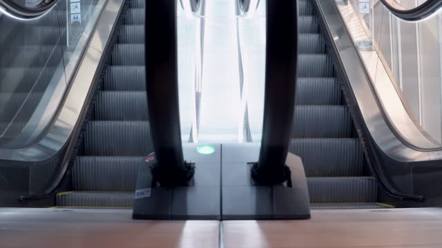 Young-man-walking-up-on-modern-escalator-stairs.-Moving-staircase-running-up-and-down.-urban-lifestyle-concept.