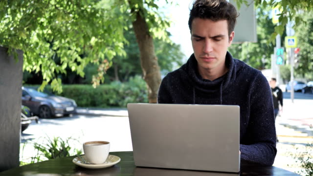 Pensive-Man-Thinking-while-Working-on-Laptop