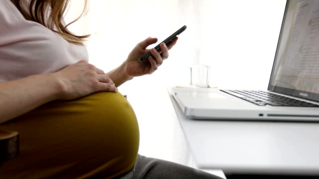 Pregnant-woman-working-with-laptop-and-phone