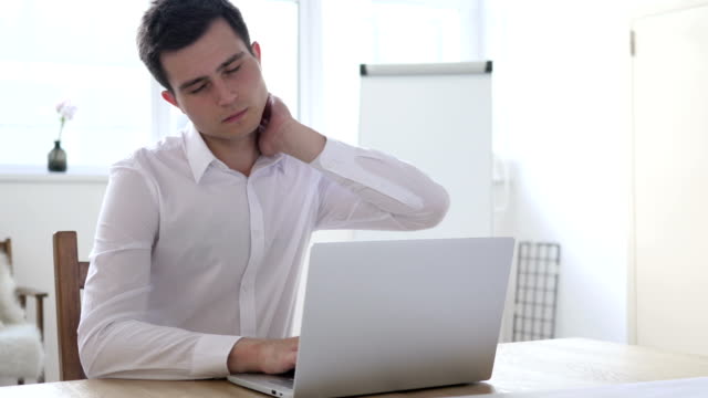 Müde-Geschäftsmann-mit-Nackenschmerzen,-die-im-Büro-arbeiten