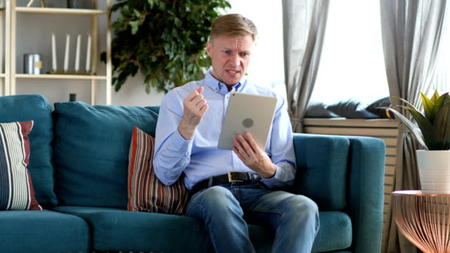 Middle-Aged-Man-Using-Tablet-Reacting-to-Financial-Loss