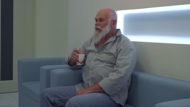 Senior-hombre-sentarse-en-el-sofá-en-la-clínica-y-esperar-su-turno