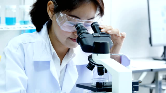 Mujer-científico-utilizando-microscopio-para-el-trabajo.-Científico-que-trabaje-en-el-laboratorio.-Personas-con-médicos,-médico,-ciencia,-concepto-profesional-de-la-salud.-Resolución-de-4K.