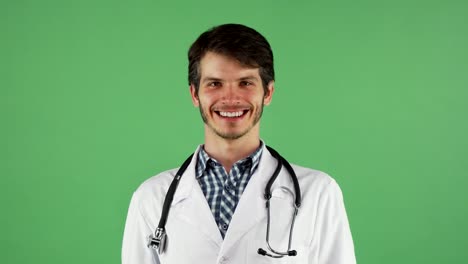 Happy-male-doctor-smiling-to-the-camera-on-chromakey