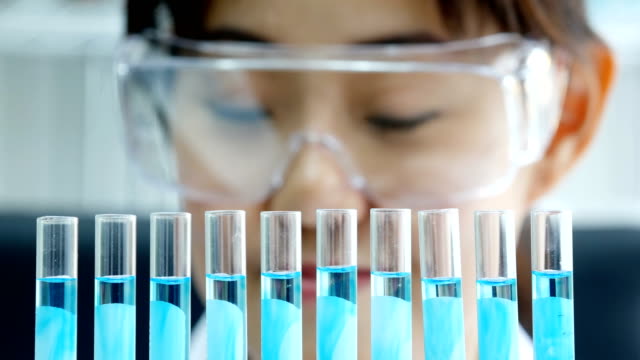 Científico-asiático-busca-sólido-en-tubo-de-ensayo.-Trabajo-de-ciencia-en-el-laboratorio.-Personas-con-médicos,-médico,-ciencia,-concepto-profesional-de-la-salud.-Resolución-de-4K.