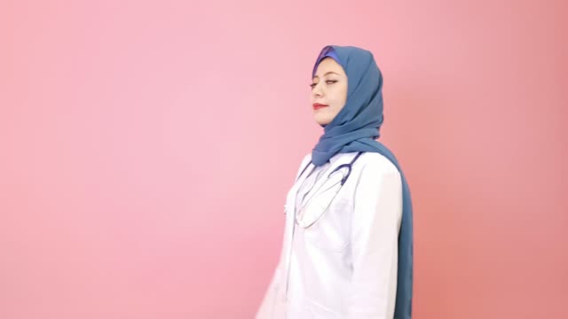 lächelnde-junge-muslimische-Frau-Doktor-Hände-gekreuzt