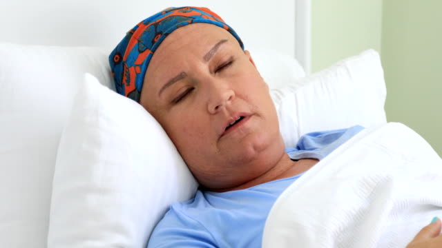 Mittlere-gealterte-Frau-mit-Krebs-auf-einem-Bett