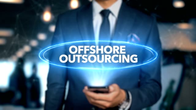 Businessman-With-Mobile-Phone-Opens-Hologram-HUD-Interface-and-Touches-Word---OFFSHORE-OUTSOURCING