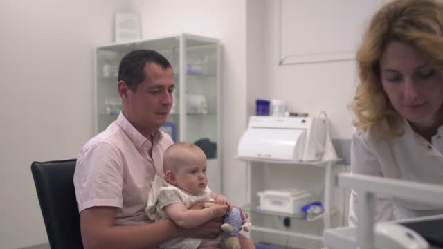 Liebender-Vater-hält-seine-kleine-Tochter-in-Armen-im-Krankenhaus