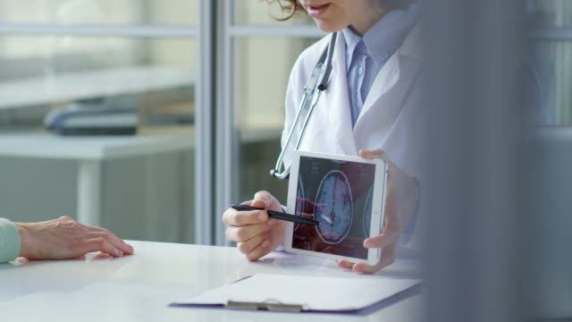 Frau-Doktor-zeigen-Scull-Röntgenbild-auf-Tablet