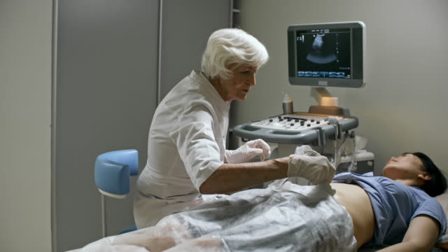Senior-weiblich-Arzt-Ultraschalluntersuchung-durchführen