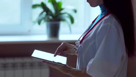 Médico-trabajando-en-una-tableta-digital-con-espacio-de-copia