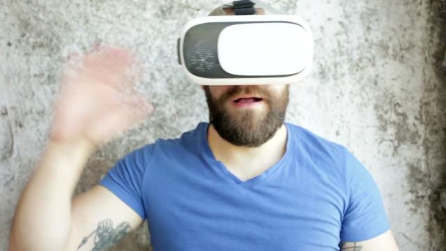 Bärtiger-Mann-verwendet-VR-Kopfhörer-Display-mit-Kopfhörern-für-virtual-Reality-Spiel.