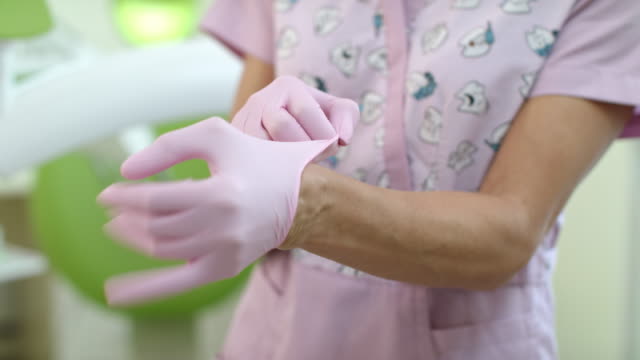 Nahaufnahme-Arzt-Händen-OP-Handschuhe-anziehen.-Frau-Zahnarzt-Hände