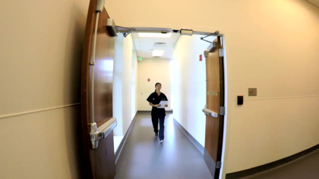Chinesische-amerikanische-Ärztin-walking-Korridor-im-Krankenhaus