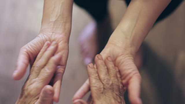 Old-wrinkled-hands-touch-the-hands-of-a-young-girl.