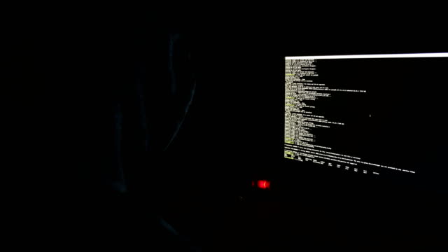 Hacker-in-der-Haube-Programme-den-Code-in-der-Dunkelheit,-der-Befehlszeile-auf-dem-Bildschirm,-4k