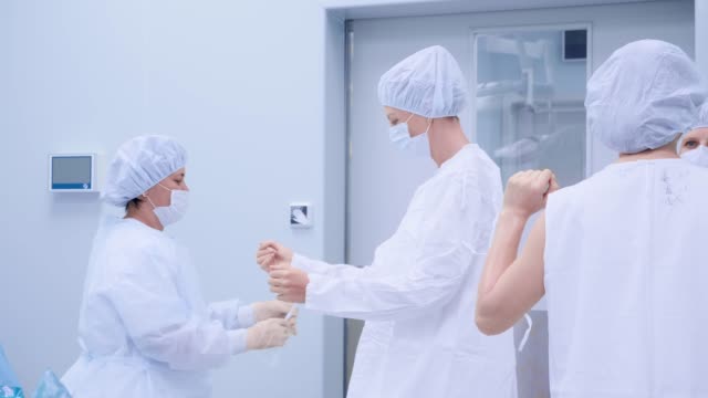 Cirujanos-en-el-quirófano-se-están-preparando-para-la-cirugía.-Usar-ropas-y-máscaras