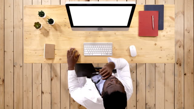 African-doctor-watching-something-on-the-screen-of-computer.-White-Display