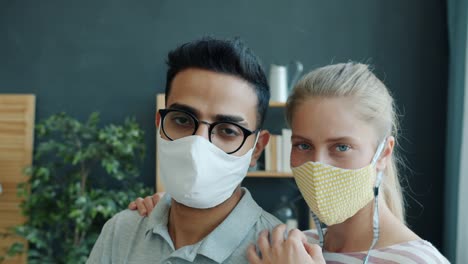 Slow-motion-portrait-of-Middle-Eastern-man-and-Caucasian-woman-in-medical-masks-indoors